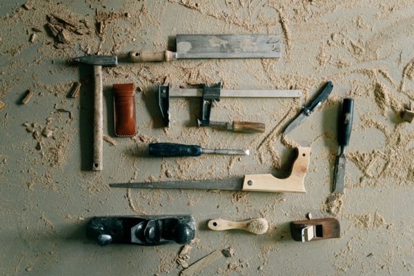 A collection of door maintenance tools placed on the messy surface.